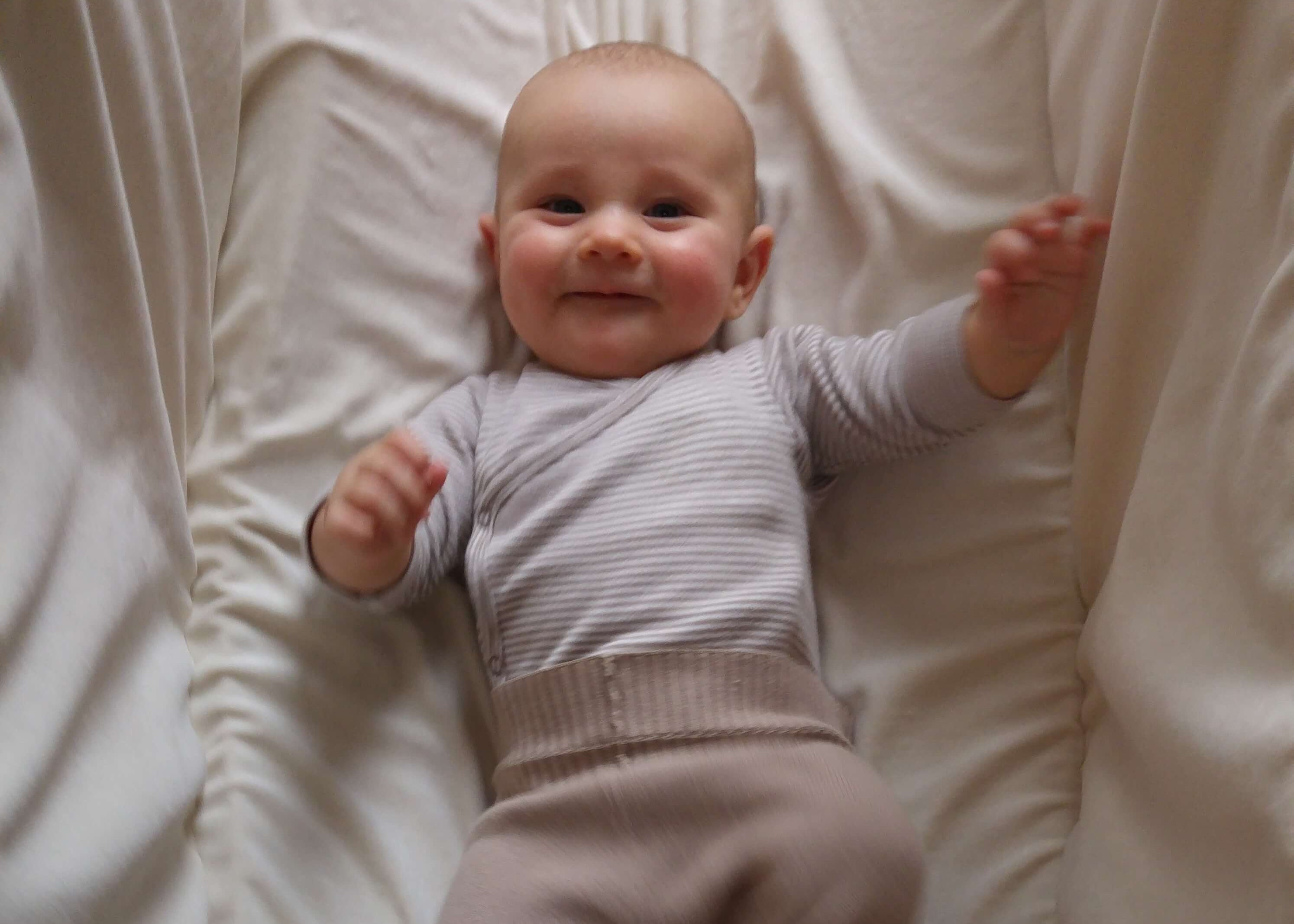 Baby freut sich in einer Wiege