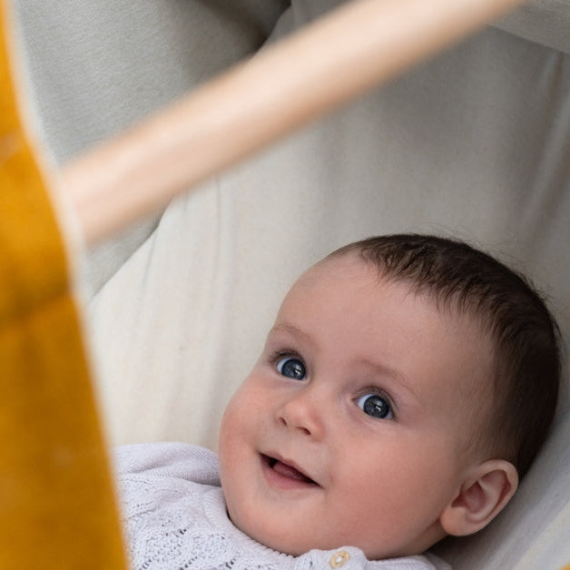 Baby lacht in Wombagee Federwiege