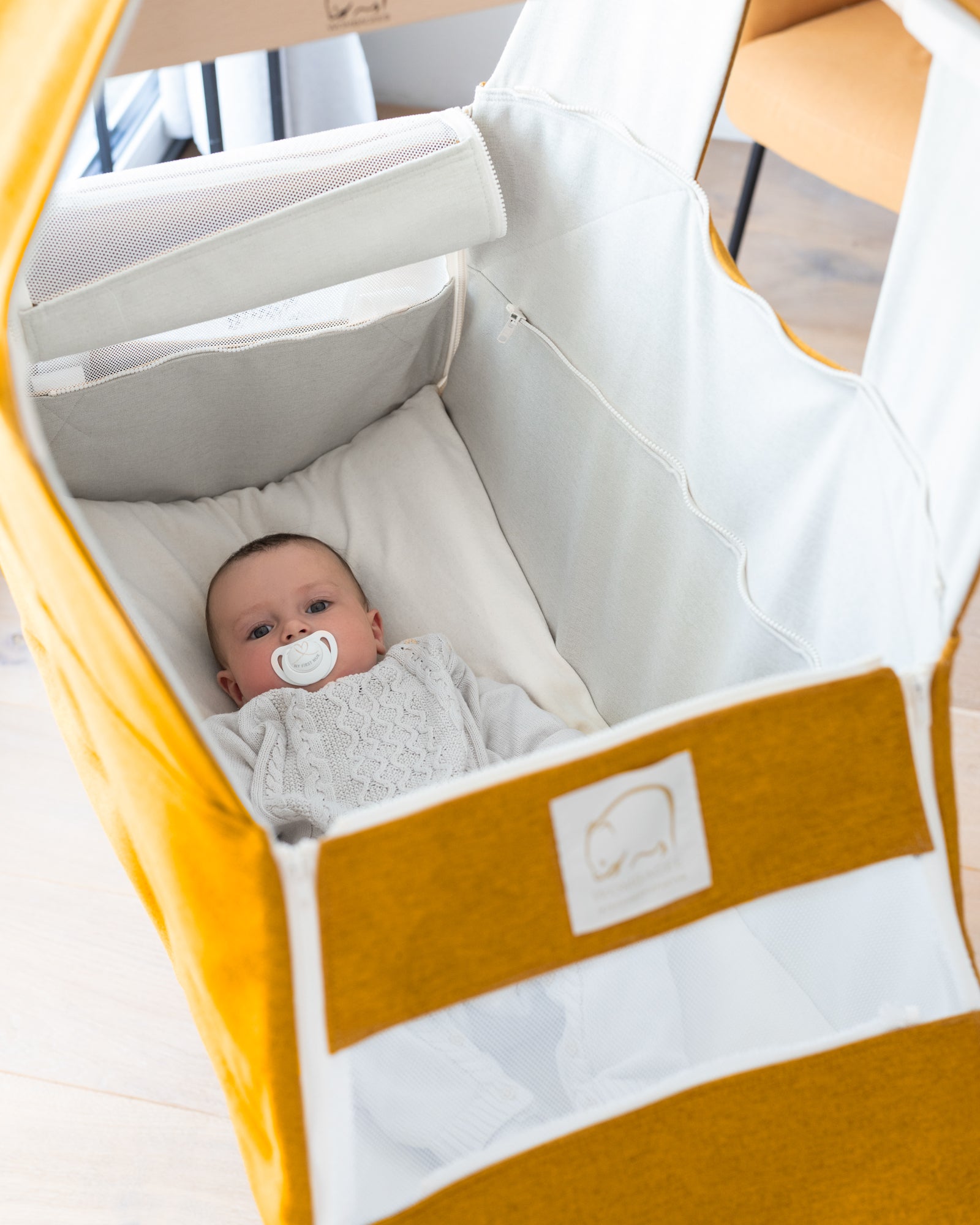 Baby liegt wach in Wombagee Federwiege Classic