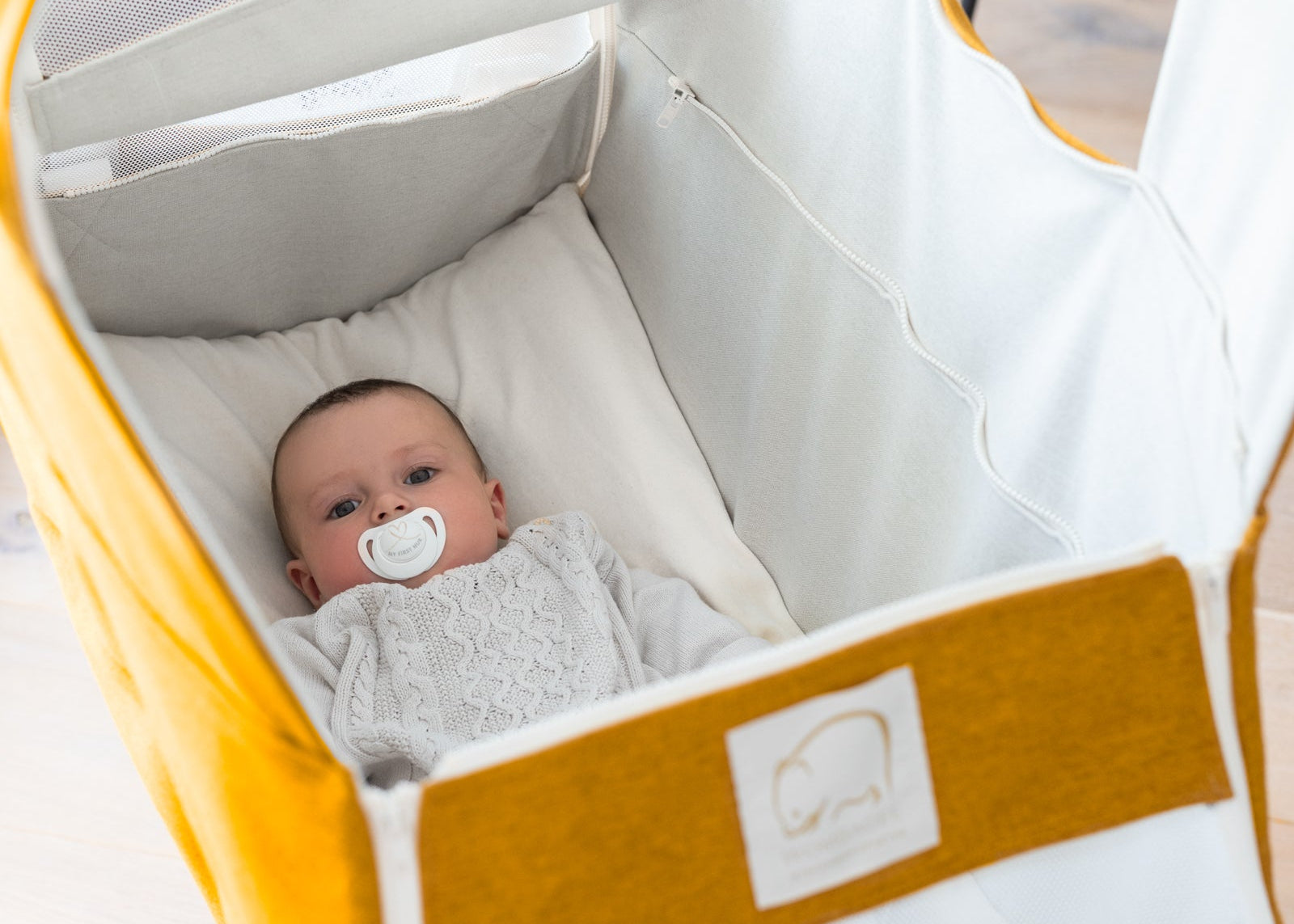 Baby liegt wach in Wombagee Federwiege Classic