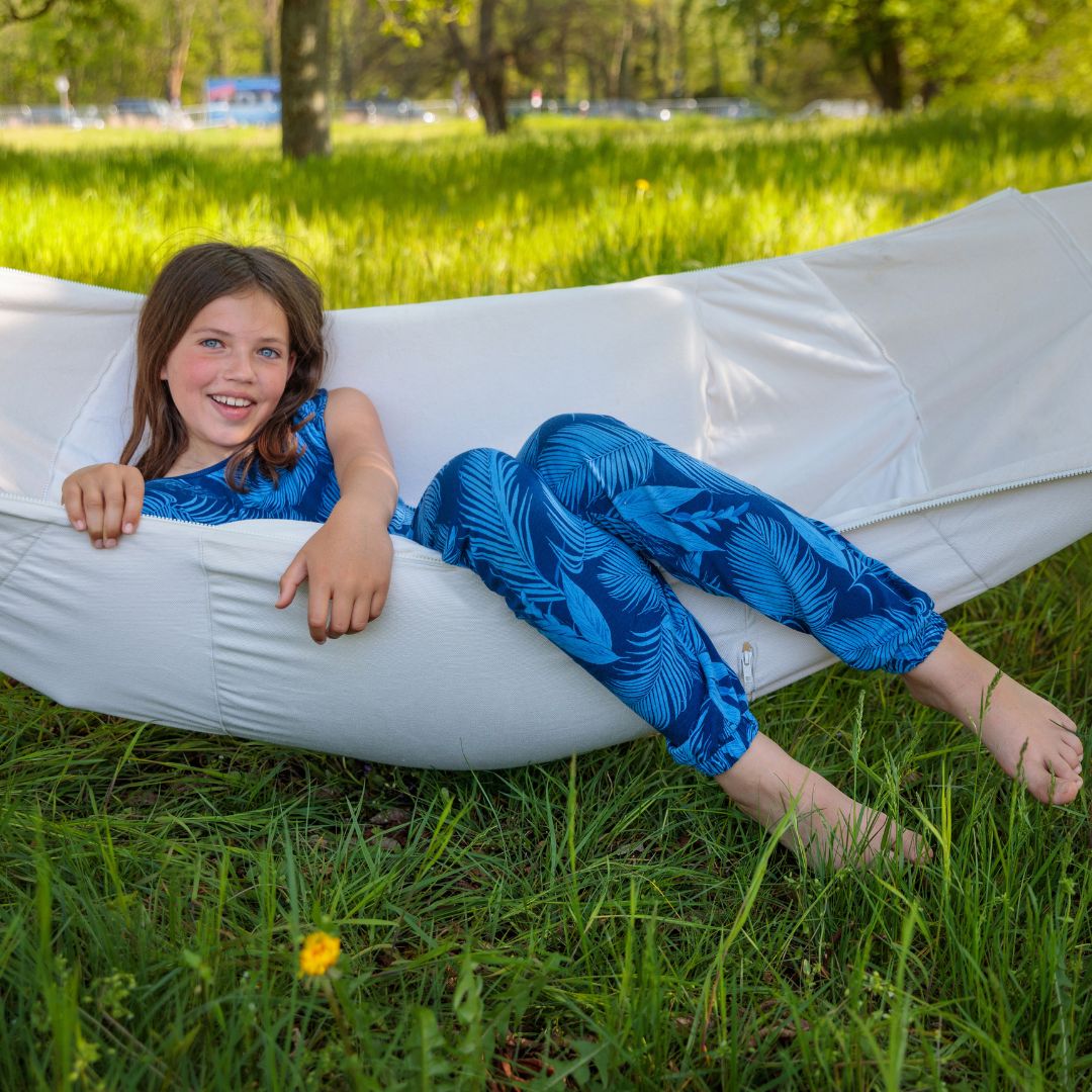 Mädchen in Hängematte mit blauem Overall