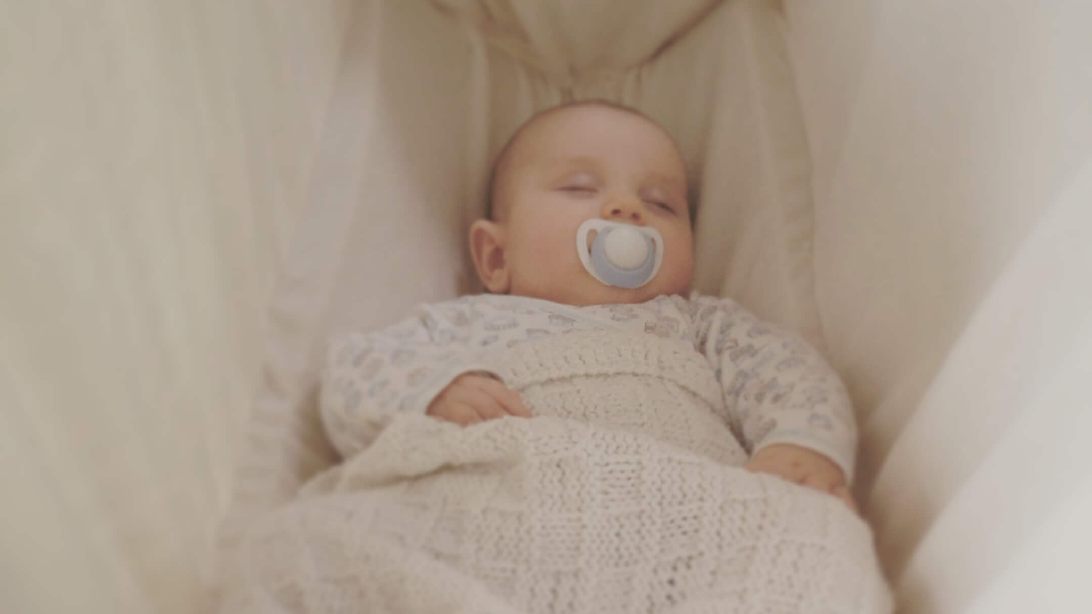 Baby schläft in Federwiege fuer Kleinkind